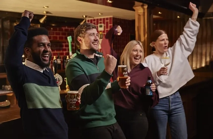 People stood at bar cheering