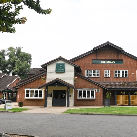 Exterior facade and car park of a pub.