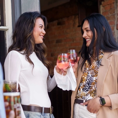 An exterior image of people stood enjoying drinks during the Q3 Happy Hour Event.