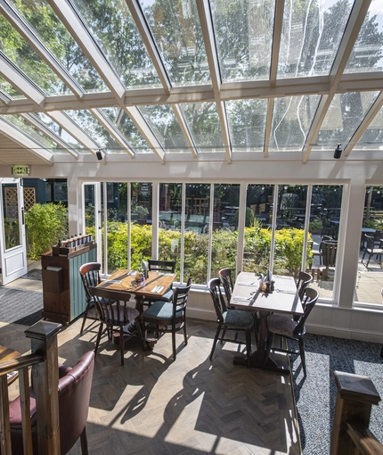 The interior conservatory restaurant seating area at The Crown & Horseshoes.