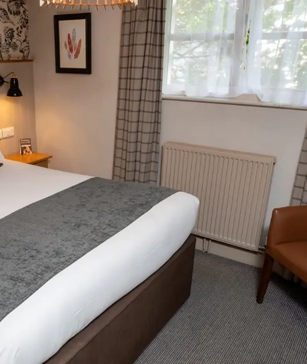 The interior hotel double bedroom with a king bed at the Cedars Inn