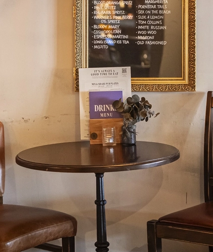 The interior restaurant seating area with framed cocktail menu at The Bull.