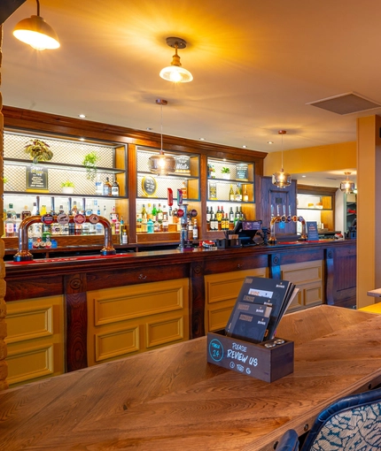 The bar and interior restaurant seating area at the Counting House, with TVs on the walls.