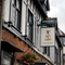 A close up view of the pub sign hanging on the exterior wall of The Talbot. The sign features an illustration of a dog standing on grass above the words "The Talbot, Worcester", on a white background.