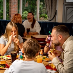 A family sat at an indoor table enjoying a meal and drinks at a Hungry Horse venue.