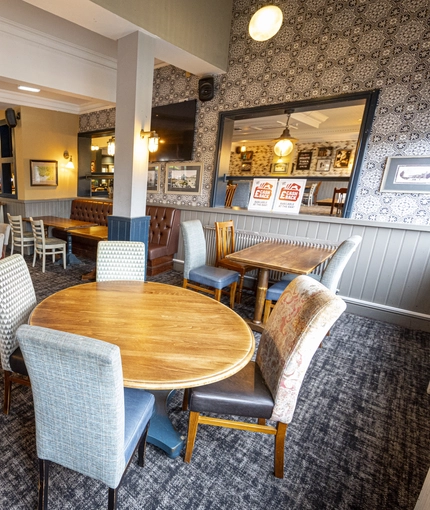 Interior dining area of a pub with a bar and a TV.