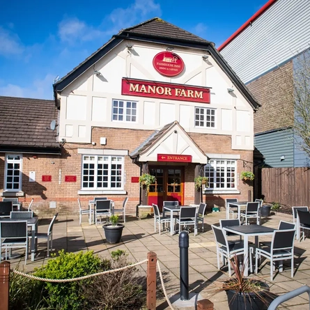 Exterior facade and beer garden of a pub with a seating area.