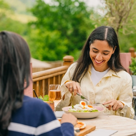 two women sitting at a table of a pub eating food