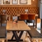 An interior restaurant seating area at The Weathervane, with upholstered chairs, benches, and booth seats, and framed artwork on the wall.