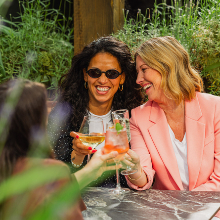 An image of people enjoying various drinks within the exterior beer garden seating area at a Crafted venue.