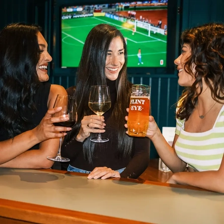 Three women watching football in the pub