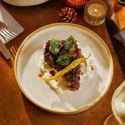 An advertising image of 2 Small Plates dishes within the interior restaurant seating area at The Foundry Bell.