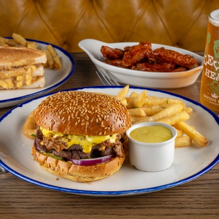 Various plated dishes for Burger of the Month July on a table.