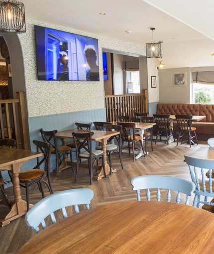 Interior dining area of a pub with a TV.