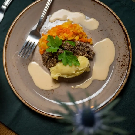 A plate of haggis, neeps and tatties next to a Glenfidditch cocktail.