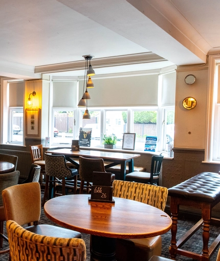 Interior dining area of a pub with a TV playing sports.