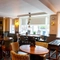 Interior dining area of a pub with a TV playing sports.