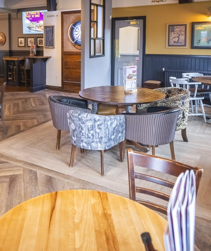 Interior dining area of a pub with a bar and a TV.