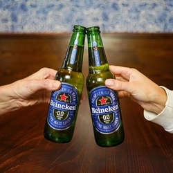 Two women cheering with a bottle of Heineken
