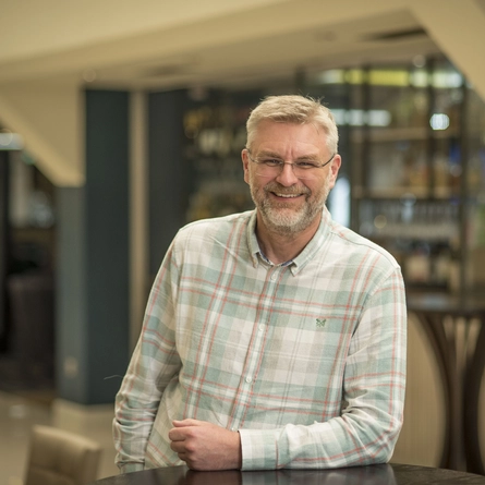 A portrait image of Dean Jordan smiling at the camera.