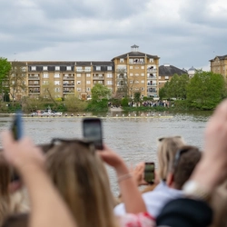 An image of boats racing on the water with crowds gathered at the waters edge for the Boat race event at The Crabtree.