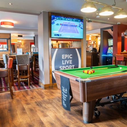 The interior restaurant seating and gaming area, with a TV on the wall and a pool table.
