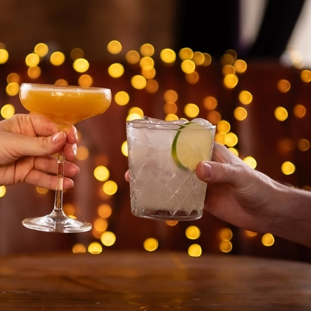 a man and a woman cheering with cocktails