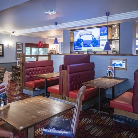 Interior dining area of a pub with TVs.