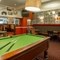 Interior dining area of a pub with a TV, a gambling machine and a pool table.