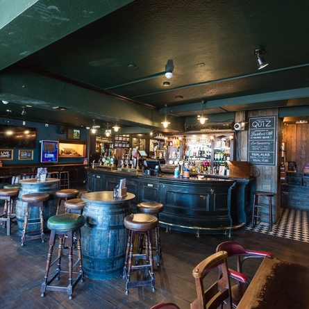 Some tables and chairs at the Turks Head, with the bar in the background.