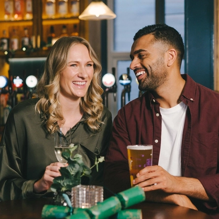 An image of 2 friends sat within the interior seating area enjoying various drinks.