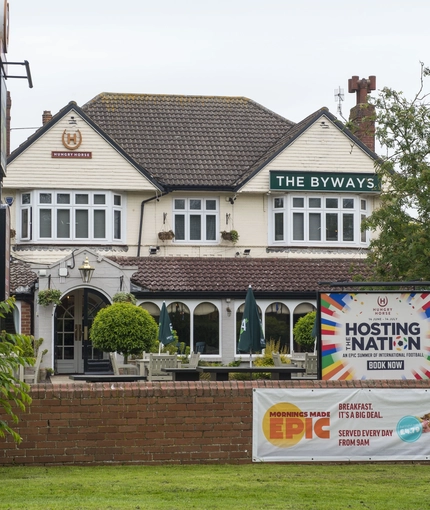 Exterior facade of a pub with a seating area.