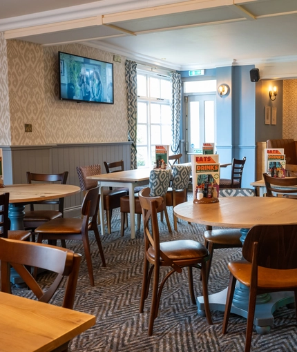 The interior restaurant and seating area with TV at The Woodlands.