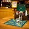 A close up view of menus, cutlery, condiments, and a tea light sitting on a wooden restaurant table at the Malvern Tavern. A Scrabble board is inlaid into the table.
