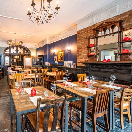 The interior restaurant seating area with ornate fireplace log storage at The Worlds End.
