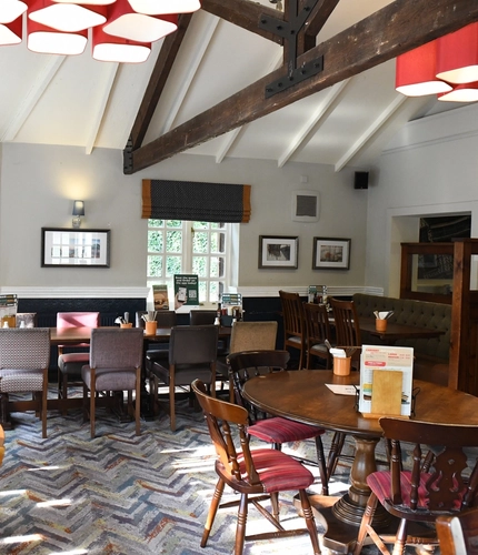 Interior dining area of a pub with a TV.