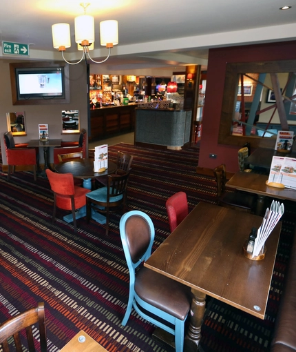 Interior dining area of a pub with a TV.