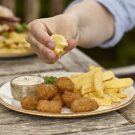 An exterior shot of lunch being served in a beer garden promoting 'Summer Lunches' at Chef & Brewer venues.