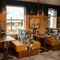 An interior restaurant seating area of The Kittoch, with upholstered booth seats, and framed artwork on the wall.