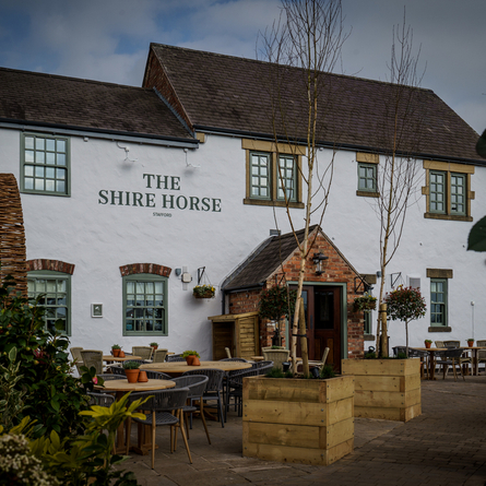 The outside of the Shire Horse, with beer garden tables in front of it.