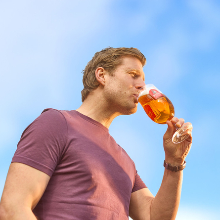 An image showing a person enjoying a pint of Madri within the exterior of a Chef & Brewer venue.