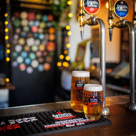 A pint and half a pint of Estrella Galicia sat on the interior bar.