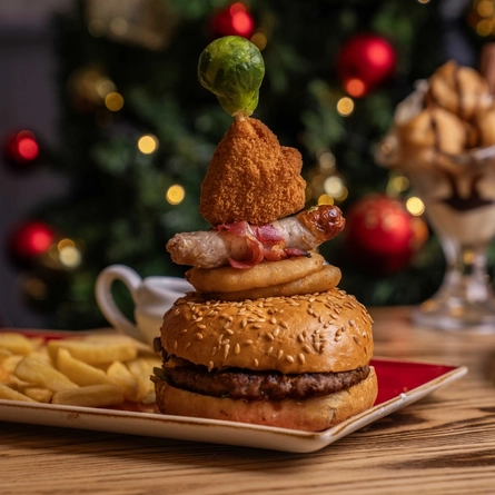 A plated Festive Burger on a wooden table.