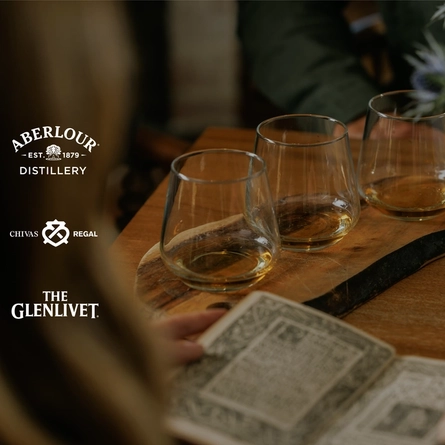 An image of a customer sat reading a poetry book with a Burns Night Whiskey Flight board sat on a table within the interior seating area at a Crafted venue.