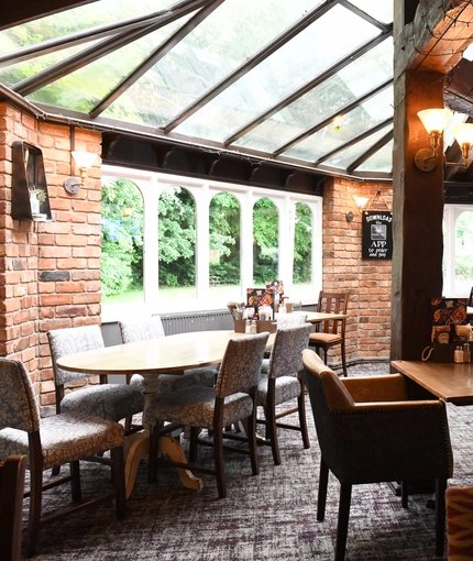 Interior conservatory of a pub with a dining area.
