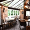 Interior conservatory of a pub with a dining area.