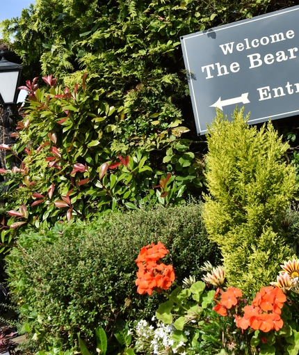 Some signs in bushes outside of The Bear Inn.