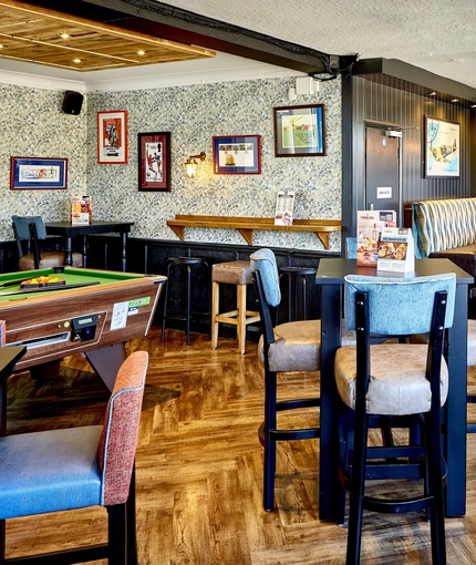 The interior restaurant seating area with pub games, at The Good Intent in Hornchurch.