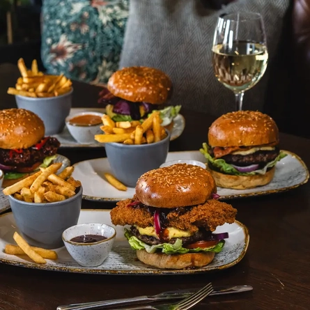 several burger meals plates on a table