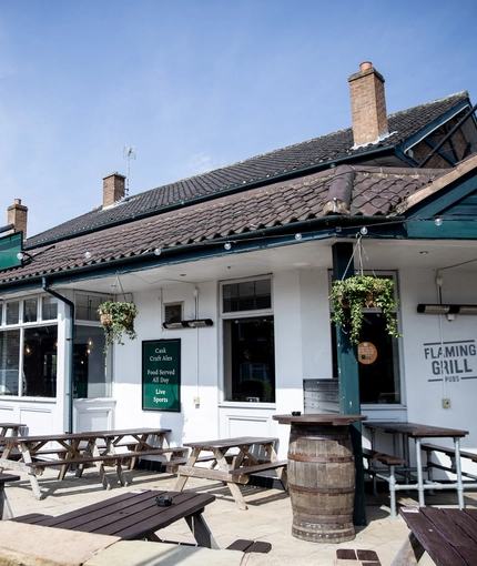 Exterior facade of a pub with a seating area.